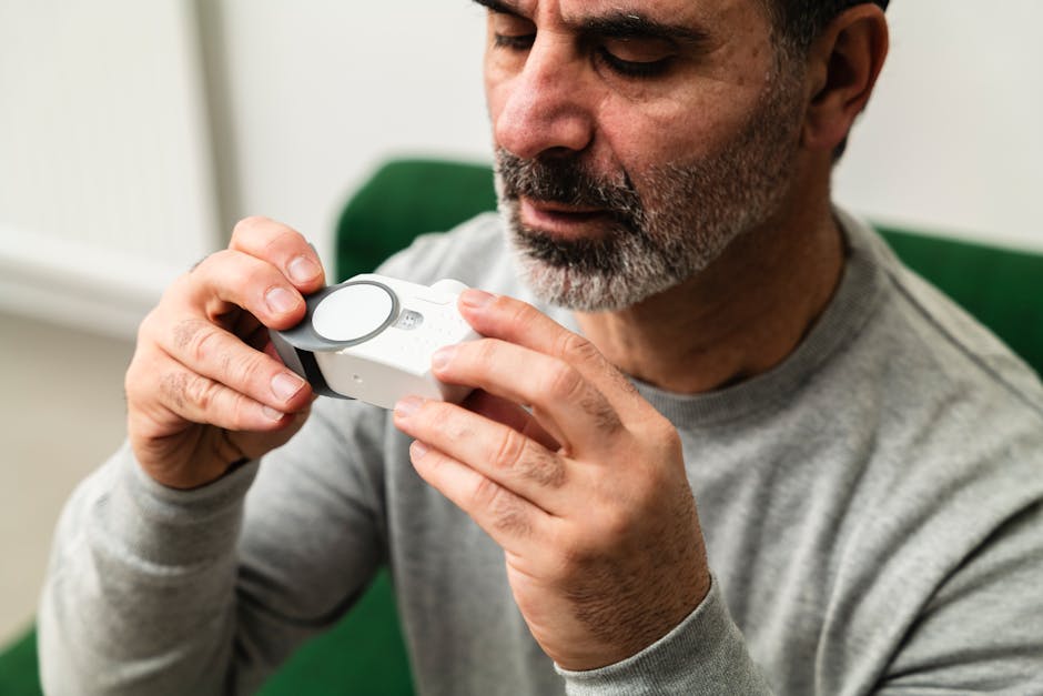 Seorang pekerja muda tampak kelelahan di depan layar laptop dan ponsel yang menyala di dalam ruangan yang redup.