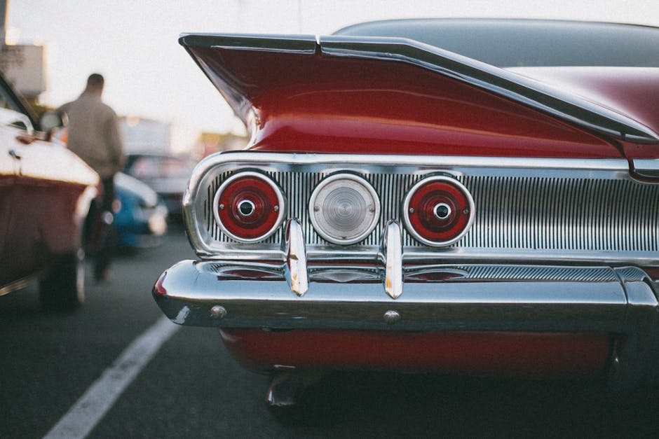 Seorang mekanik profesional sedang memeriksa detail komponen mesin motor dengan teliti di sebuah bengkel yang bersih.